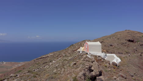 Aerial:-Orbit-shot-of-a-small-church-on-a-Greek-island-at-top-of-a-hill