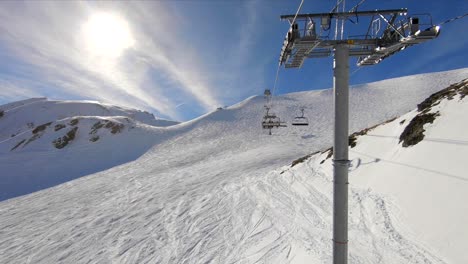 Blick-Von-Einem-Skilift-über-Eine-Skipiste-In-Einer-Verschneiten-Berglandschaft,-An-Einem-Sonnigen-Tag