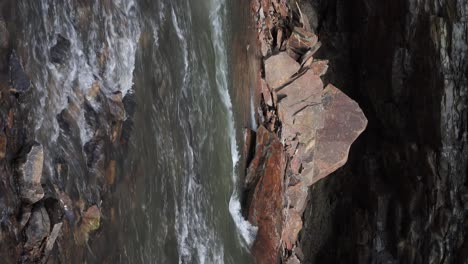 Vertical-video-of-water-flow-on-a-river-with-rocks,-Central-Pennsylvania