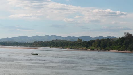 Un-Barco-Navegando-A-Través-Del-Río-Mekong-Contra-La-Corriente,-Tailandia-Y-Laos