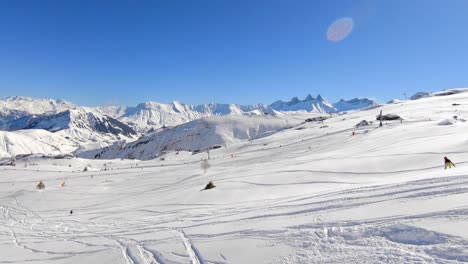 Drohnenaufnahme-Von-Skifahrern,-Die-Abseits-Der-Piste-über-Einen-Schneebedeckten-Berghang-Fahren