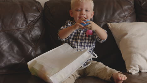 Slow-motion-shot-of-a-young,-blonde-boy-playing-with-a-blue-Easter-egg