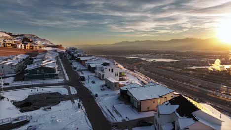 AERIAL---Snowy-winter-sunrise-in-Ridge-North-residential-sector,-North-Salt-Lake,-Utah