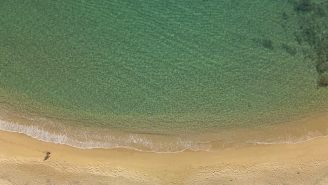 Luftaufnahme-Von-Oben-Nach-Unten-Mann-Allein-Zu-Fuß-An-Einem-Wunderschönen-Exotischen-Strand-Mit-Klarem-Wasser-Und-Ruhigen-Wellen