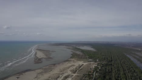 drone-video-over-the-Divjake-Karavasta-nature-park,-frontal-shot-advancing-over-the-shore-of-the-beach-and-the-trees