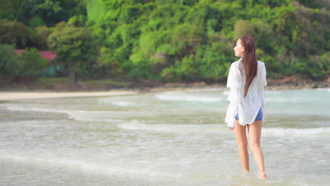 A-pretty-young-woman-walks-alone-in-the-incoming-waves