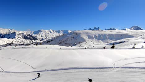 Luftaufnahme,-Die-Sich-über-Einen-Schlepplift-Und-Eine-Skipiste-In-Einem-Verschneiten-Wintersportgebiet-Bewegt,-Mit-Fernen-Berggipfeln-Im-Hintergrund