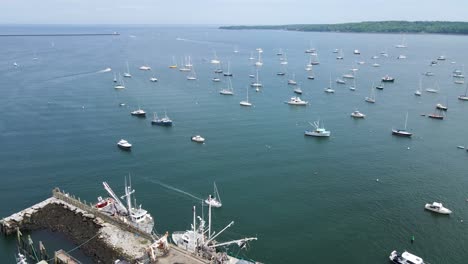 Boats-Docked-in-Bay-at-Rockland-Harbor,-Maine-|-Aerial-View-Panning-Across-|-Summer-2021