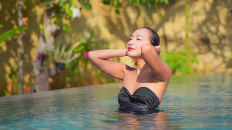 Beautiful-Exotic-Woman-in-Infinity-Swimming-Pool-on-Tropical-Destination,-Slow-Motion