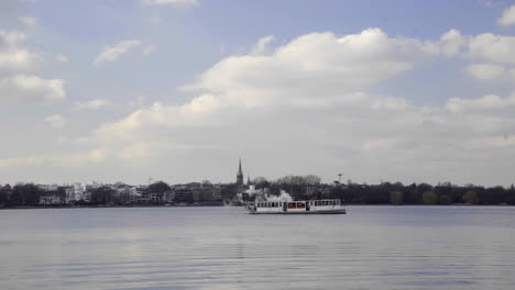 Barkasse-boat-on-empty-Alster-Lake-in-Hamburg-Germany-against-blue-sky