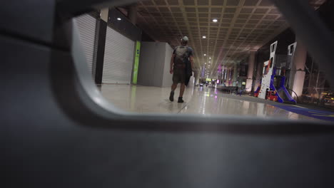 young-caucasian-backpacker-travel-walking-alone-in-early-morning-wearing-a-protective-mask-inside-the-airpot-reaching-the-gate-for-boarding-in-the-plane