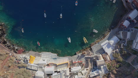 Aerial:-Top-down-shot-of-Ammoudi-Bay-in-Oia-of-Santorini-with-many-small-boats