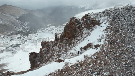 Vista-Aérea,-Hombre-Solitario-Caminando-En-Las-Montañas-En-Un-Frío-Día-De-Invierno,-Colorado-Mines-Usa---Drone-Shot