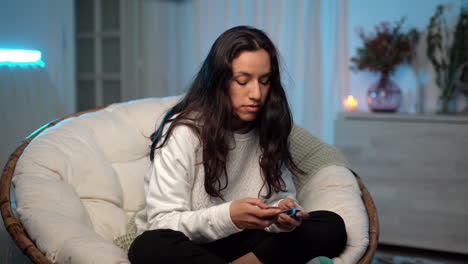 Young-female-multiracial-woman-playing-videogame-with-wireless-remote-modern-controllers,-sitting-on-comfortable-couch-yawning-in-boredom-and-tiredness