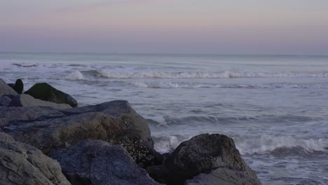 Blue-hour-with-pink-sky-at-the-beach-with-rocks-in-Ocean-City,-New-Jersey