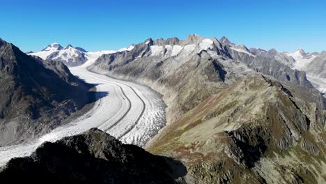 Aerial-flyover-alongside-the-Bettmerhorn-next-to-the-longest-glacier-in-the-Alps---the-Aletsch-glacier-in-Valais,-Switzerland-on-a-sunny-summer-afternoon