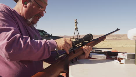 Man-adjusting-his-rifle-scope-at-the-gun-range