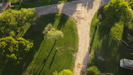 Aerial-top-down-shot-of-Gardener-cutting-green-grass-in-Park-during-sunny-day,Uruguay