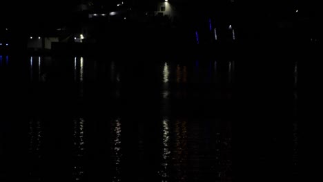Luces-Que-Se-Reflejan-En-El-Agua-Oscura-De-Un-Lago-Por-La-Noche,-Concepto-Tranquilo-Y-Pacífico