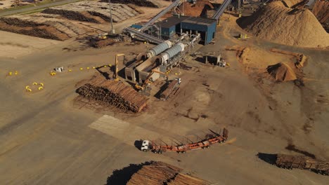 Aerial-shot-of-industrial-crane-unloading-wooden-trunks-of-Truck-for-production-line-in-paper-mill-factory