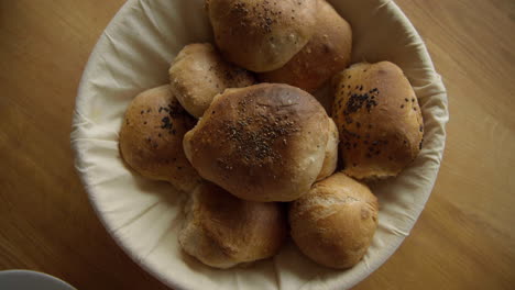 Top-shot-of-self-made-freshly-baked-breakfast-rolls-buns-on-the-breakfast-table-in-a-bread-basket-on-a-relaxed-weekend-morning