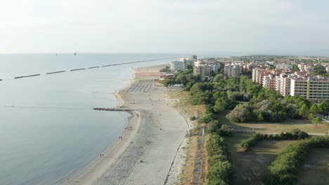 Aerial-shot-of-sandy-beach-with-umbrellas-and-adriatic-sea,-typical-Emilia-Romagna-shore