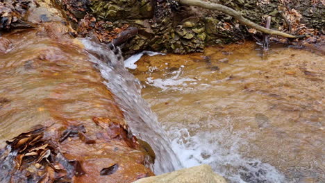 Waterfall-of-a-creek-water-stream-in-the-woods-on-a-winter-day