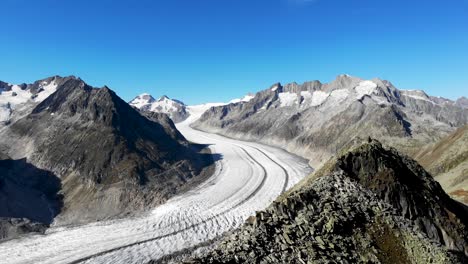 Aerial-flyover-over-the-Bettmerhorn-next-to-the-longest-glacier-in-the-Alps---the-Aletsch-glacier-in-Valais,-Switzerland-on-a-sunny-summer-afternoon