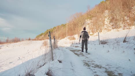 Hombre-Caminando-Por-Un-Sendero-De-Montaña-Cubierto-De-Nieve-En-Polvo-En-Un-Soleado-Día-De-Invierno-En-Vikan,-Indre-Fosen,-Noruega