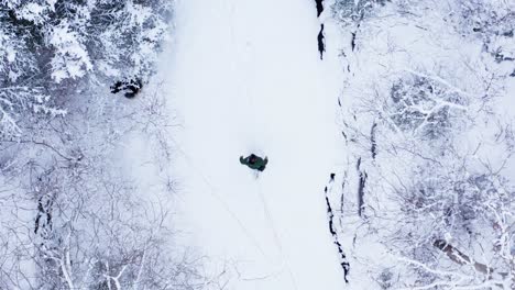 Guy-Walking-On-Deep-Snow-Forest-With-His-Dog