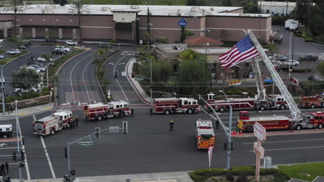 firefighters,-fire-trucks,-and-police-officers-wait-for-a-funeral-procession,-to-show-their-support-for-a-fallen-officer