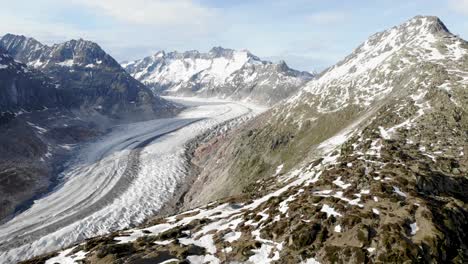 Panoramic-aerial-view-of-the-Aletsch-Glacier-in-Wallis,-Switzerland,-which-is-the-longest-glacier-of-the-Swiss-Alps-and-Europe-with-a-spinning-view-of-the-surrounding-peaks