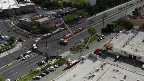 Aerial-drone-of-police-and-fire-trucks-with-huge-American-flag