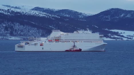 Schlepper-Neben-Einem-Kreuzfahrtschiff-Am-Fjord-In-Vikan,-Indre-Fosen,-Norwegen-In-Der-Abenddämmerung