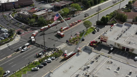 A-group-of-firefights,-police-officers,-fire-trucks,-police-trucks-wait-for-a-funeral-procession-to-honor-a-fallen-officer