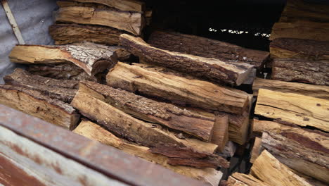 Piles-of-firewood-stacked-high-in-shed,-4K