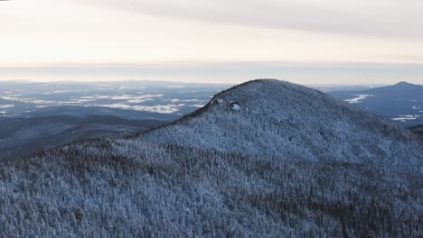 Panoramic-View-of-Snow-Covered-Mountain-Peaks-of-Eastern-Townships-Quebec-Canada---Right-Panning-Aerial-Shot