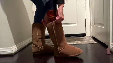 Close-Up-Female-Putting-On-Brown-Boots-In-Hallway-In-Slow-Motion