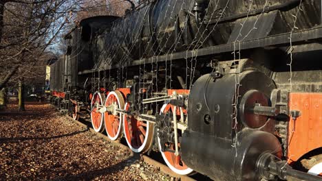 Antique-steam-locomotive-and-wagons-on-railway-in-park-on-winter-day