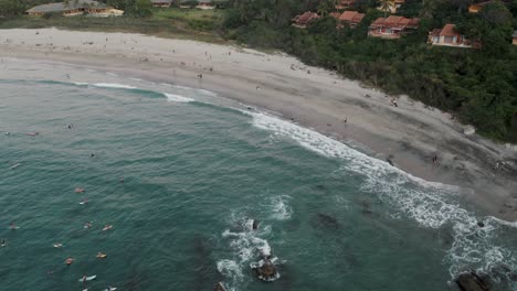 Scenic-Seascape-With-Tourists-Enjoying-At-Puerto-Escondido,-Mexico---aerial-drone-shot