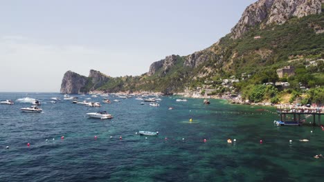 Vista-De-La-Costa-De-Amalfi-Del-Parque-Natural-De-Punta-Campanella,-Italia-A-Lo-Largo-De-La-Costa-En-Temporada-De-Verano-Con-Un-Gran-Número-De-Barcos-Atracados-Cerca-De-La-Costa