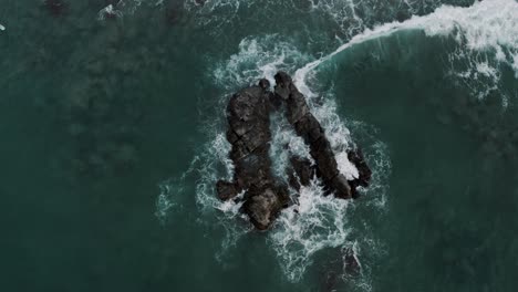 Top-down-View-Of-Waves-Crashing-On-Rocks-At-Puerto-Escondido,-Oaxaca,-Mexico---drone-shot