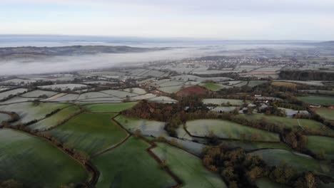 Aerial-reverse-shot-of-a-Devon-countryside-Valley-in-England-with-River-mist-and-frost