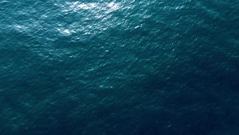 Aerial-Shot-Beautiful-Smooth-Water-Surface-Of-Dark-Blue-Clear-Sea