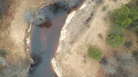 AERIAL:-Flying-Above-Shallow-Dark-Water-River-in-Eastern-Europe