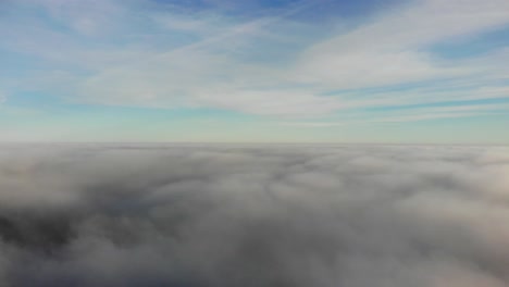 Aerial-forward-flying-shot-above-and-skimming-the-clouds