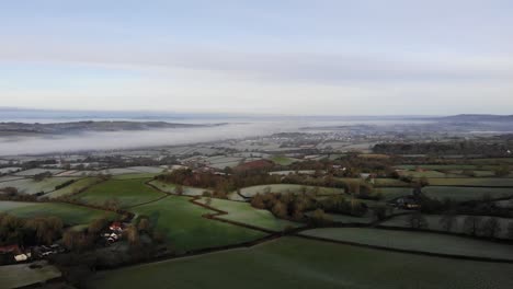 Aerial-forward-shot-over-the-English-Countryside-on-a-frosty-morning-with-river-mist-as-a-backdrop