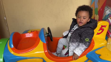 Bebé-Afroeuropeo-De-2-Años-Disfrutando-En-Un-Avión-De-Juguete