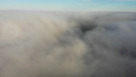 Aerial-rising-shot-through-and-above-the-clouds-showing-the-blue-sky-above