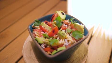 Delicious-Fusilli-Pasta-Salad-In-A-Bowl-Mixed-With-Tomato,-Avocado,-And-Nuts